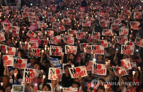 광복절이었던 지난 15일 오후 서울 광화문광장에서 열린 '아베 규탄 범국민촛불대회'에서 참가자들이 촛불을 밝히며 '노(NO) 아베' 구호를 외치고 있다. <연합뉴스>